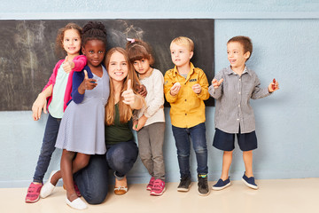 Kinder und Lehrerin mit Daumen nach oben