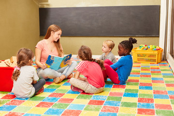 Gruppe Kinder und Lehrerin beim Vorlesen