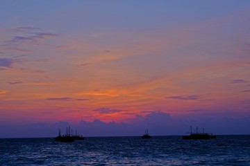 Naklejka na ściany i meble Beautiful sunset sky with silhouette fisherman boats
