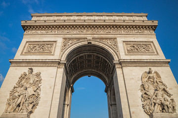 Fototapeta na wymiar Low angle shot the Arc de Triomphe, Paris France, at the center of Place Charles de Gaulle, formerly named Place de l'Etoile