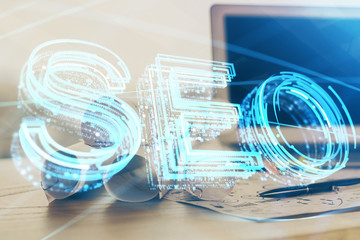 Multi exposure of table with computer and seo drawing hologram. Search optimization concept.