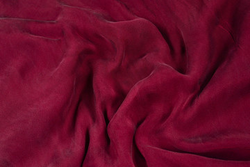 Soft smooth burgundy silk fabric background. Fabric texture.