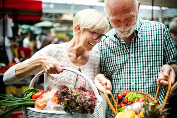 Mature couple shopping vegetables and fruits on the market. Healthy diet.