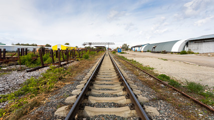 large plan railroad tracks against the background of a construction site, production workshop, warehouse, gantry crane. Industrial concept of transportation, loading and storage of goods
