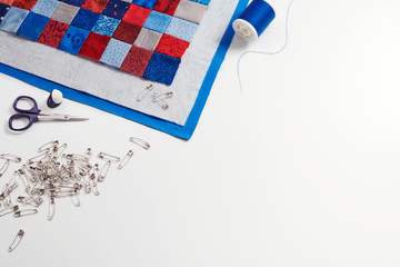 Assembling of a quilt sandwich, curved basting pins and sewing accessories, space for text