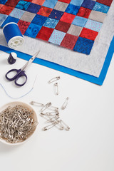 Assembling of a quilt sandwich, curved basting pins and sewing accessories, space for text