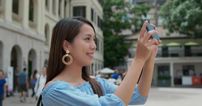 Woman tourist take photo on cellphone and visit old landmark in Hong Kong