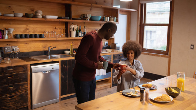Couple eating and having coffee in their kitchen