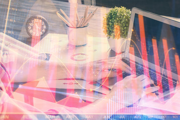 Naklejka premium Double exposure of stock graph with businessman typing on computer in office on background. Concept of hard work.