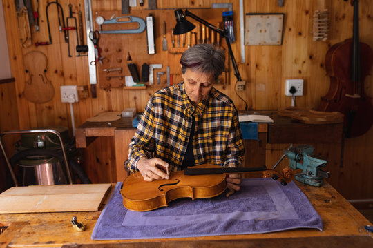 Female violin maker at work in a workshop