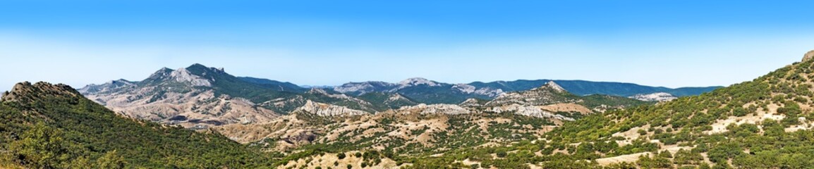 Fototapeta na wymiar beautiful mountain valley panorama landscape against blue sky outdoor travel panoramic view of wide Karadag mountain range and Sun valley on late summer in Crimea scenic nature scenery famous landmark