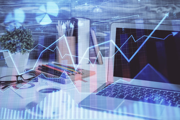 Forex market graph hologram and personal computer on background. Double exposure. Concept of investment.