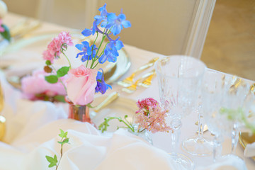 Banquet table with forks, knives, plates and flowers and berries
