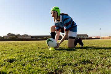 Young adult female rugby player on a rugby pitch