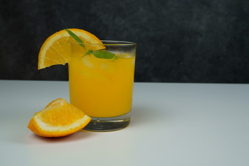 A glass of fresh orange juice on white table