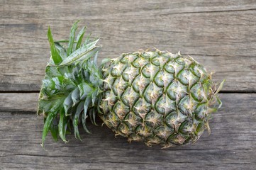 green pineapple fruit on wood plank
