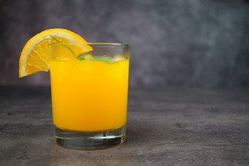 Fototapeta na wymiar A glass of fresh orange juice on grey background.