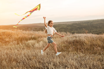 Cheerful girl with kite in field