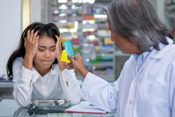 Selective focus of senior asian pharmacist man discussion how to use contraceptive pill and condom...