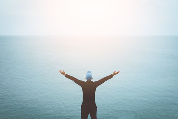 Copy space of man raise hand up on blue sky at beach and island background.