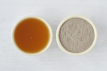 Homemade face mask made out of apple cider vinegar and clay on wooden background