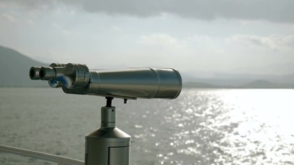 Close-up shot of tourist binoculars on deck of cruise ship against Mediterranean sea. Greece. 4K
