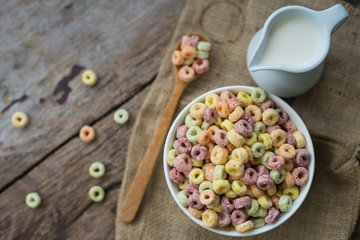 Milk and cornflakes in bowl on the wooden table