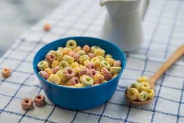 Milk and cornflakes in bowl on the wooden table