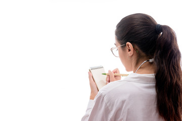 Caucasian young female doctor with glasses and stethoscope prescribing in a notebook on white background isolated
