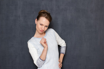 Studio shot of comic flirty girl imitating sexy photo pose