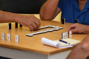 Fototapeta na wymiar Group of senior people in retirement home playing domino game