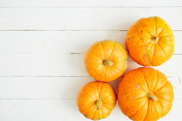 Pumpkins on white wooden background. Thanksgiving and Halloween concept. View from above. Top view. Copy space for text and design