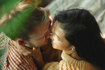 Fototapeta premium Couple of lovers at home relaxing together. Caucasian man and woman having weekend, looks tender and happy. Concept of relations, family, autumn and winter comfort. Domestic romantic.