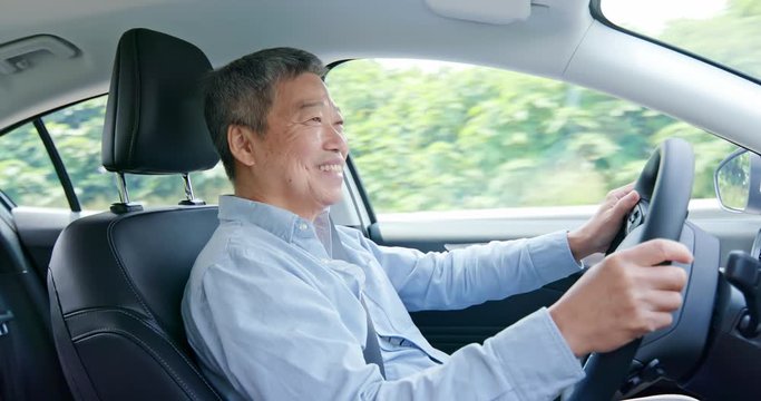 asian elderly man driving car