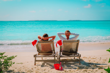 Christmas on beach -chair lounges and happy couple relax at sea