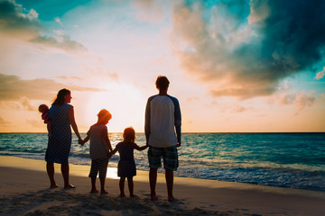 happy family with tree kids walk at sunset beach