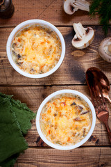 Chicken julienne and mushrooms in portion forms on a wooden table, selective focus