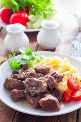 Beef stew with mashed potatoes on a white plate, selective focus