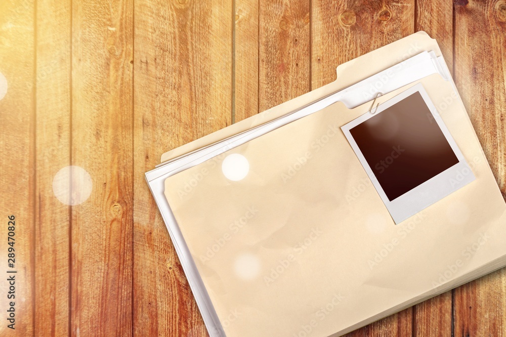 Poster file folder with documents and blank photo in wooden table