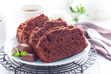 Sliced chocolate muffin on a white plate, selective focus