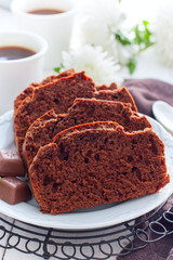 Sliced chocolate muffin on a white plate, selective focus