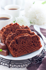 Sliced chocolate muffin on a white plate, selective focus