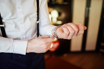 the groom straightens the wedding suit