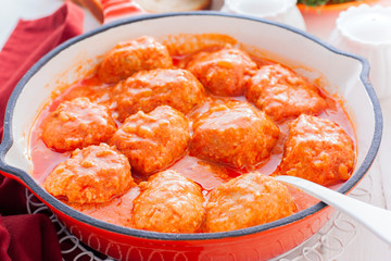 Chicken meatballs in a pan in tomato and sour cream sauce, horizontal