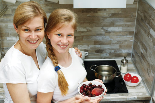 A cute child and mom cook healthy food together.