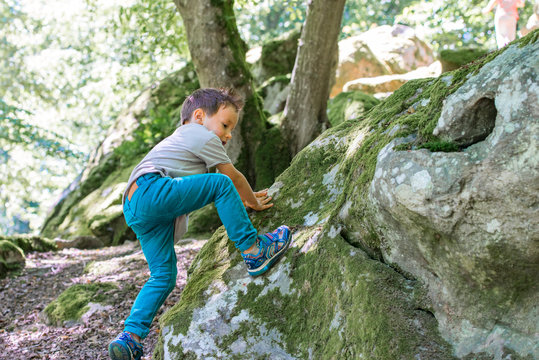 enfant grimpant sur un rocher 