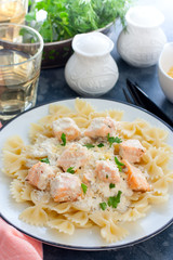 Farfalle with salmon in a creamy sauce, selective focus