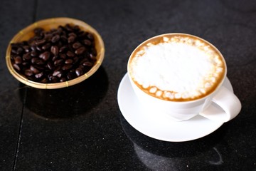 cup of coffee with beans on white background