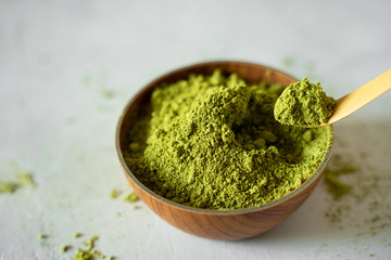 Matcha tea in a brown cup on a gray background