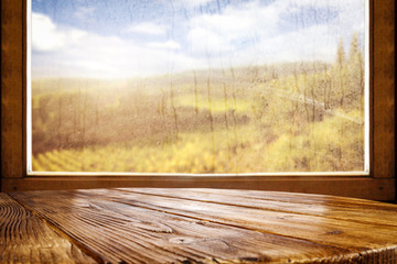 Plakat Wet autumn window and wooden old table background 